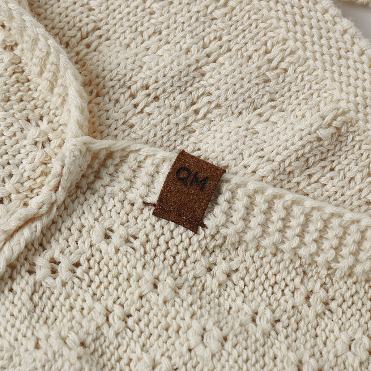 A cream-colored knit with a textured diamond pattern.