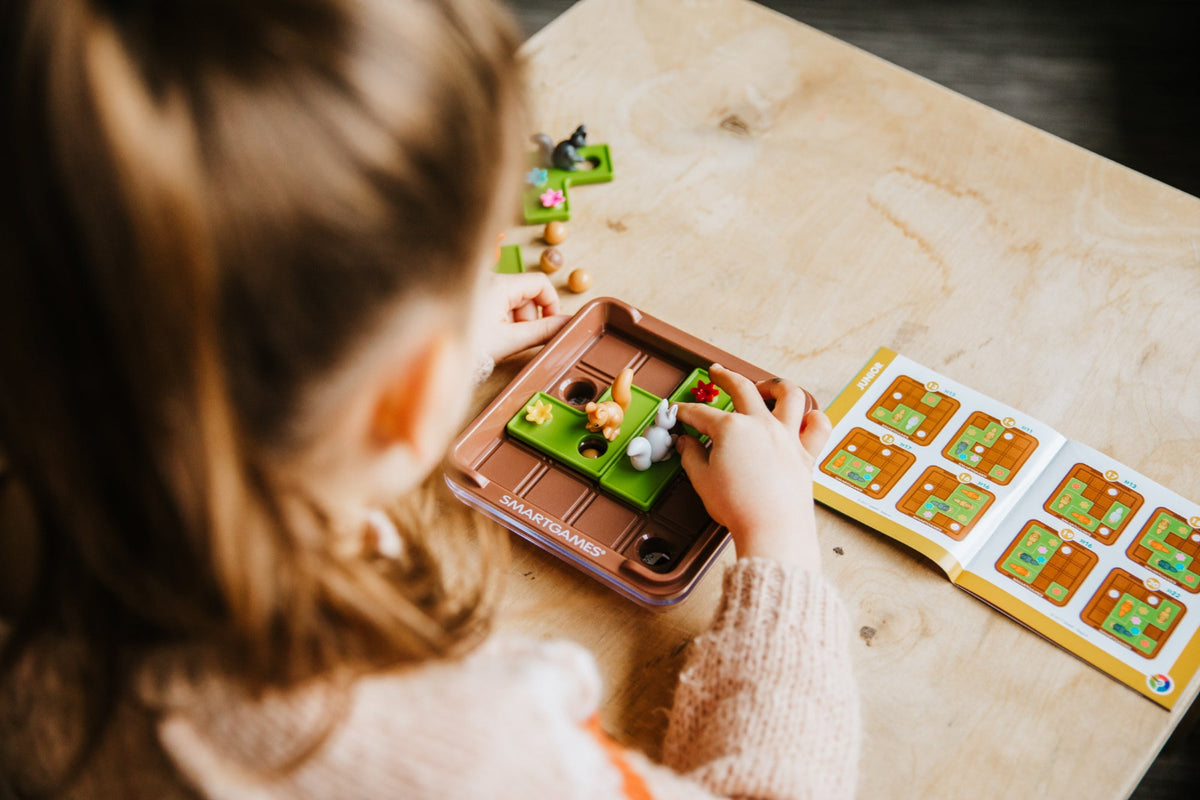 Child playing with a board game on a wooden table