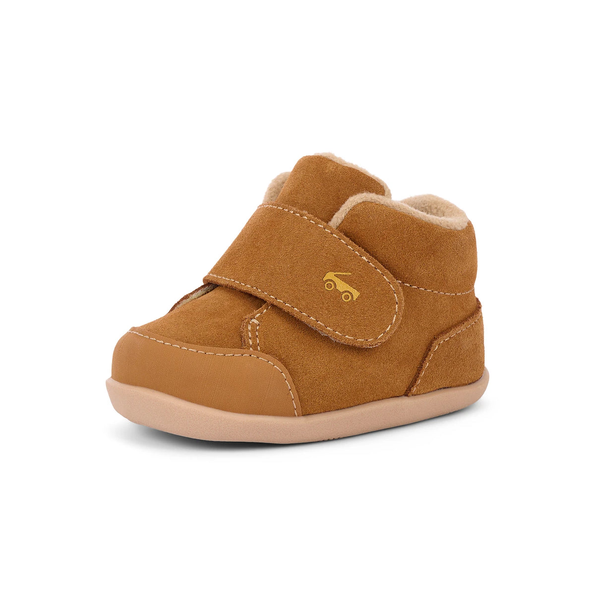 A single toddler bootie in tan suede with a plush cream lining, featuring a hook-and-loop strap closure with a small gold car logo and a light tan sole, shown on a white background.