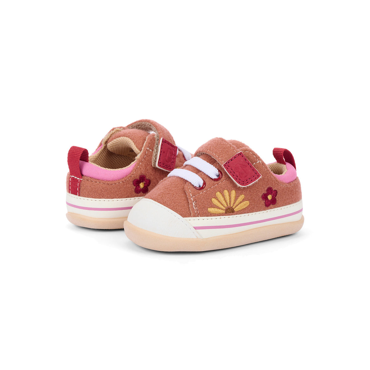 A pair of toddler's low-top sneakers in dusty rose pink suede, featuring pink elastic hook-and-loop straps, white laces, embroidered red and yellow flowers, and a white rubber toe cap and sole.