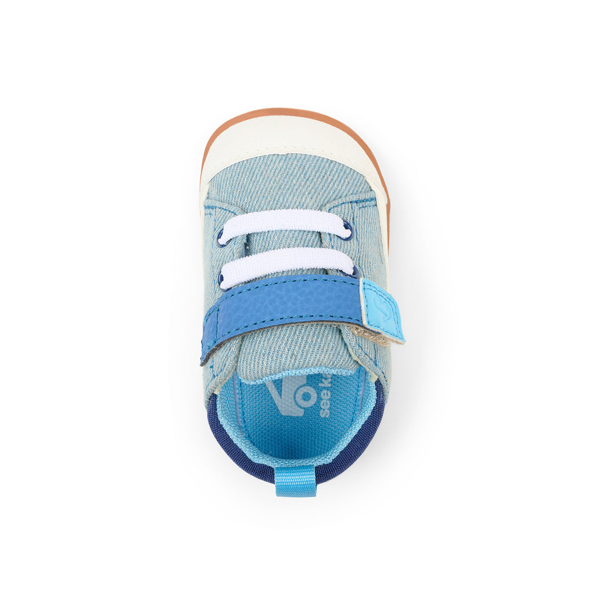A single toddler shoe from the brand Havaianas, shown from a top-down view on a white background. The shoe features a light blue denim canvas upper, white laces, a bright blue hook-and-loop strap, a navy blue heel tab, and a light brown rubber outsole.