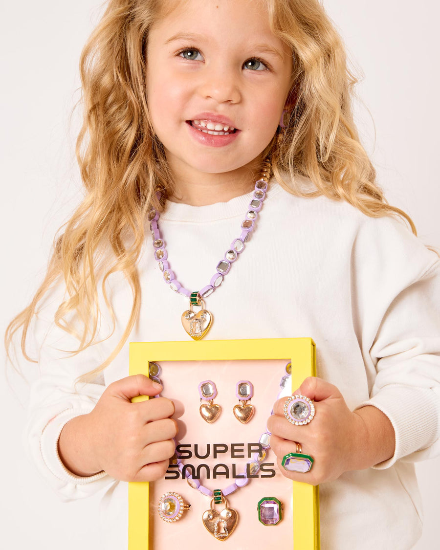 Young girl holding a display of jewelry with a 'Super Smiles' box.