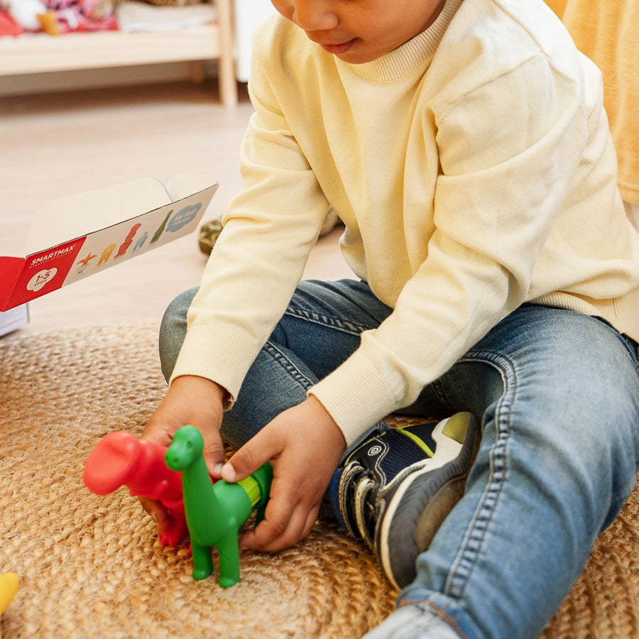 Child playing with colorful toy figures on a carpeted floor