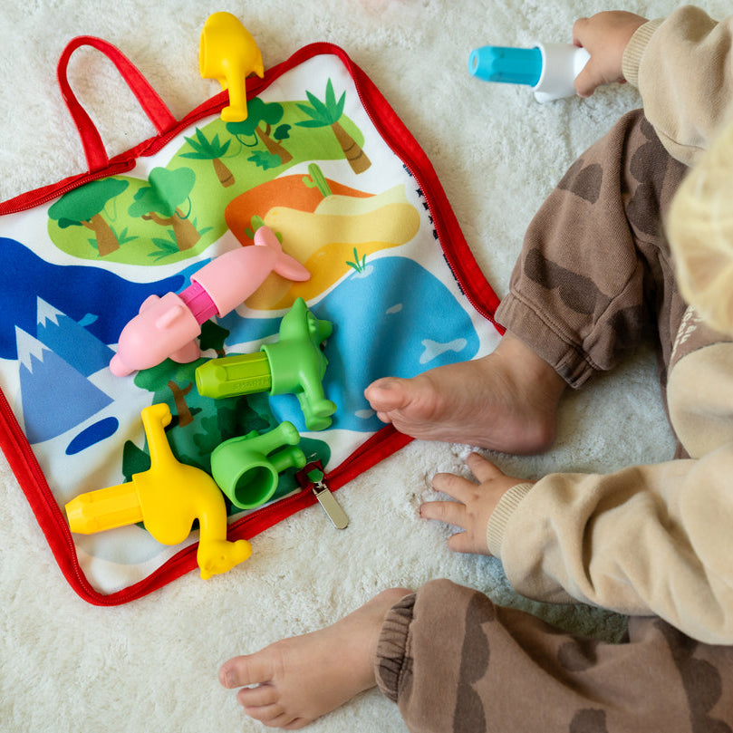 Child playing with a colorful educational toy on a light-colored floor.