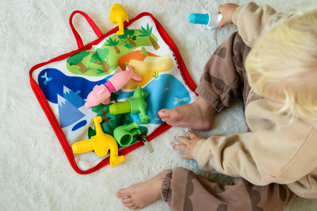 Child playing with a colorful educational toy on a light-colored floor.