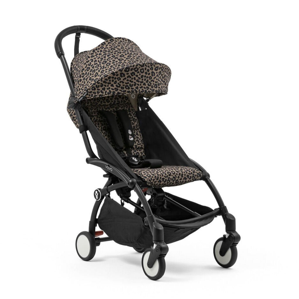 A compact stroller with a black frame and leopard print fabric canopy and seat, shown on a clean white background.