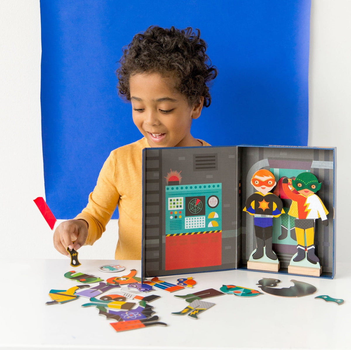 Child playing with a toy set featuring colorful figures and a puzzle on a white surface.