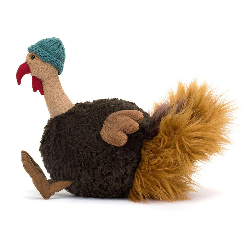 Plush toy resembling a turkey with a knitted hat on a white background