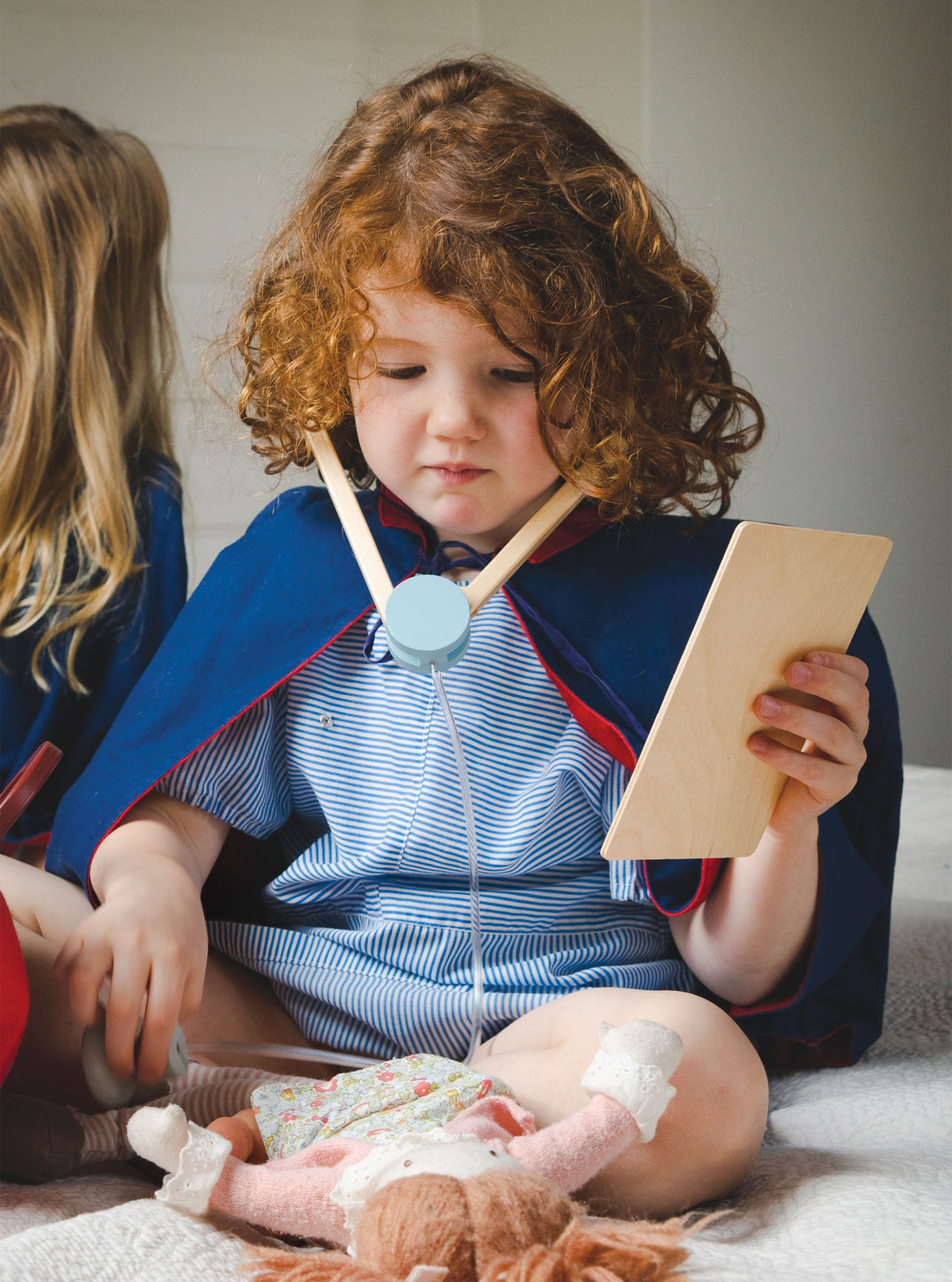 Two children playing with toys on a bed