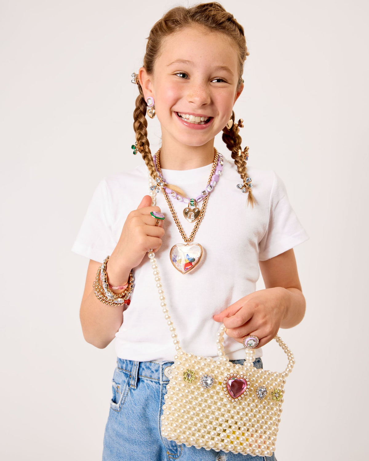 Young girl holding a decorative handbag with a plain background