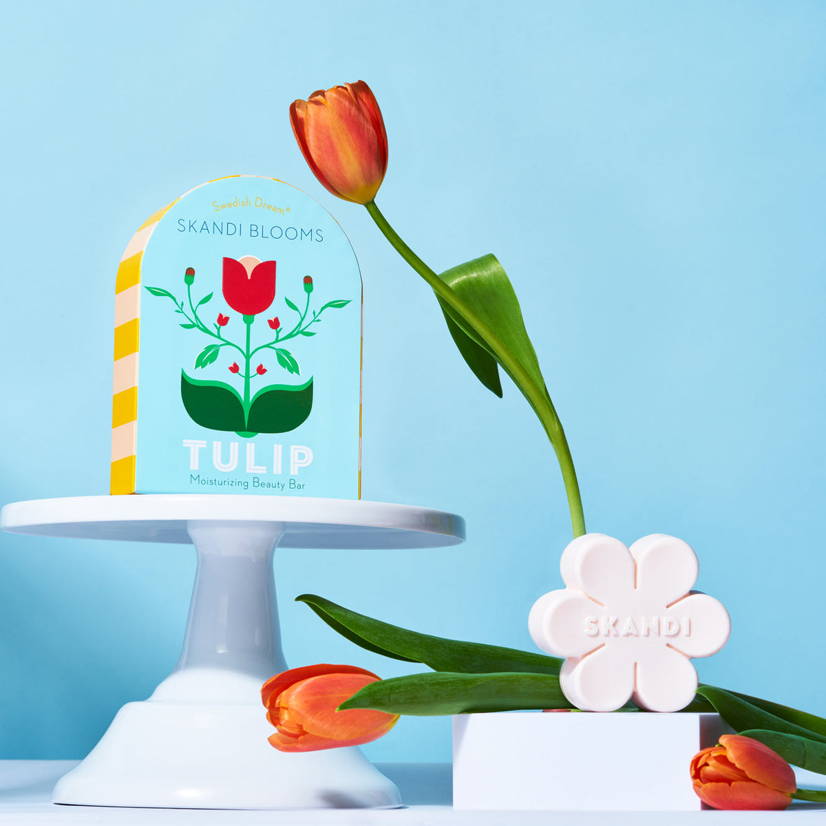 Skandi Blooms tulip product with packaging and soap on a blue background