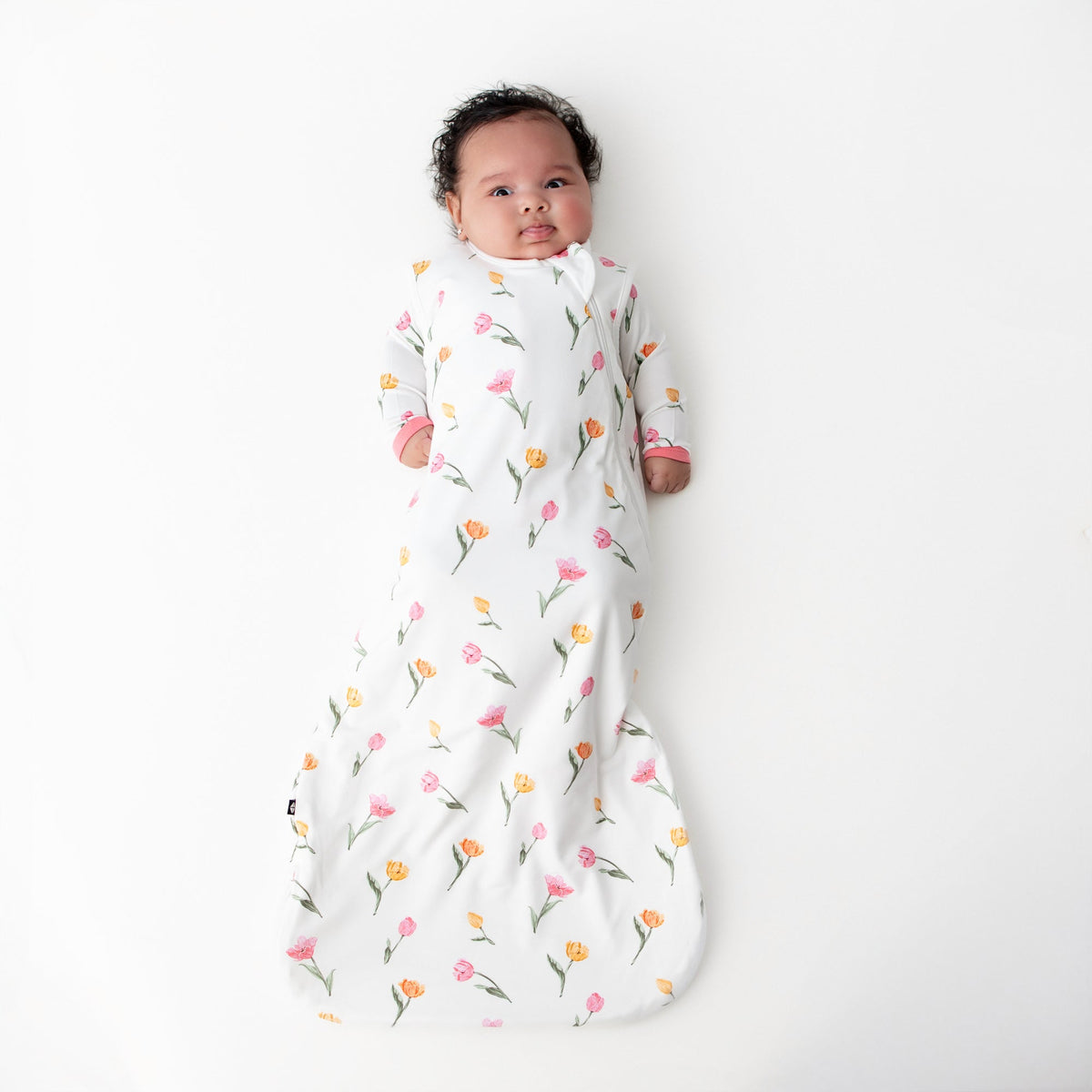 Baby wrapped in a floral swaddle on a white background