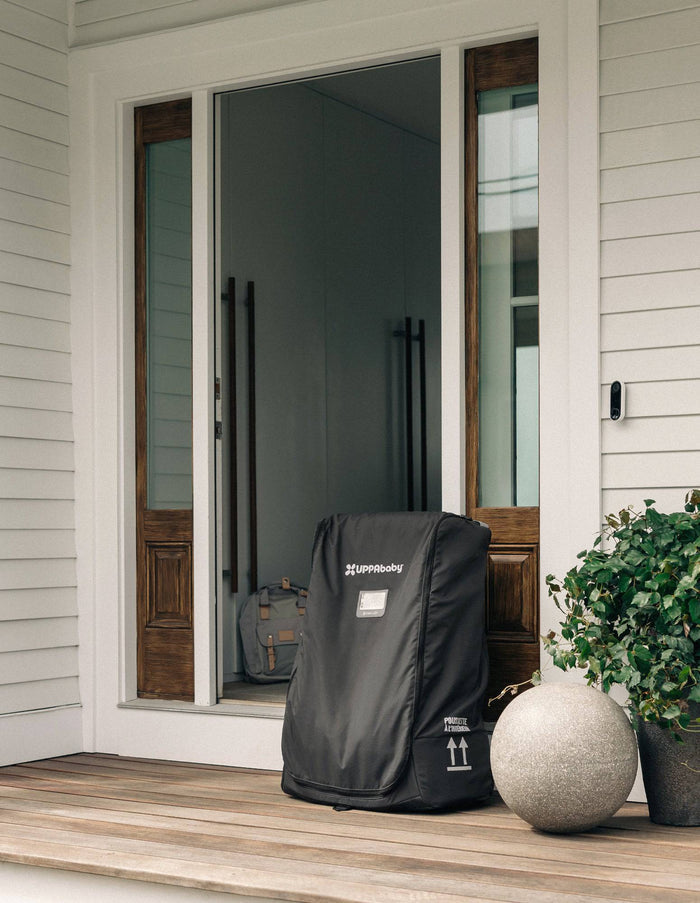 Black storm door cover on a front porch with a house in the background