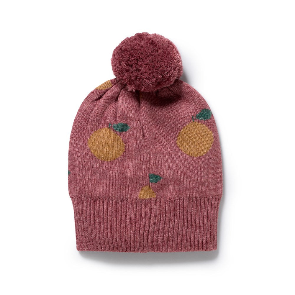Knitted hat with pom-pom and fruit pattern on a white background