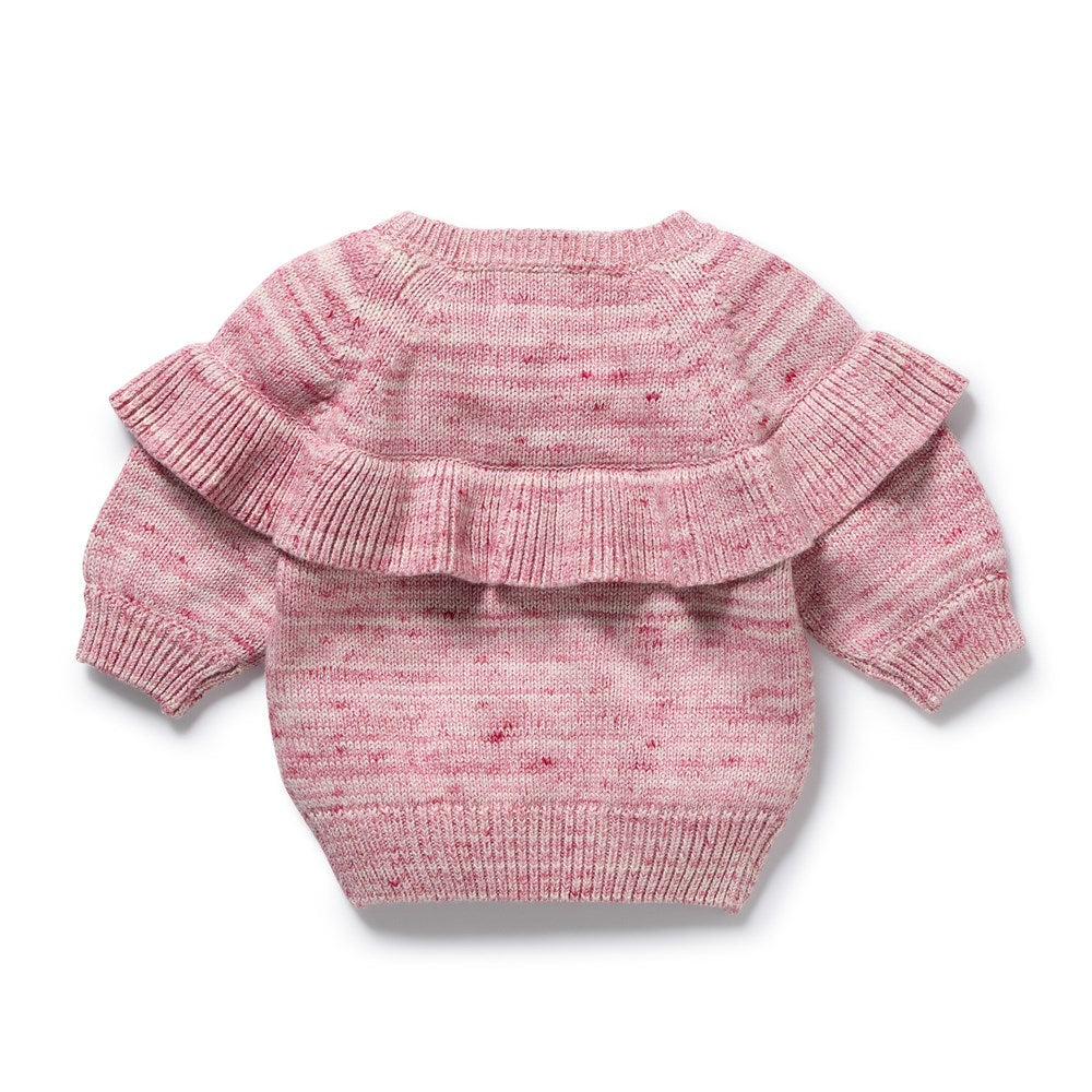 Pink knitted baby sweater with ruffled details on a white background