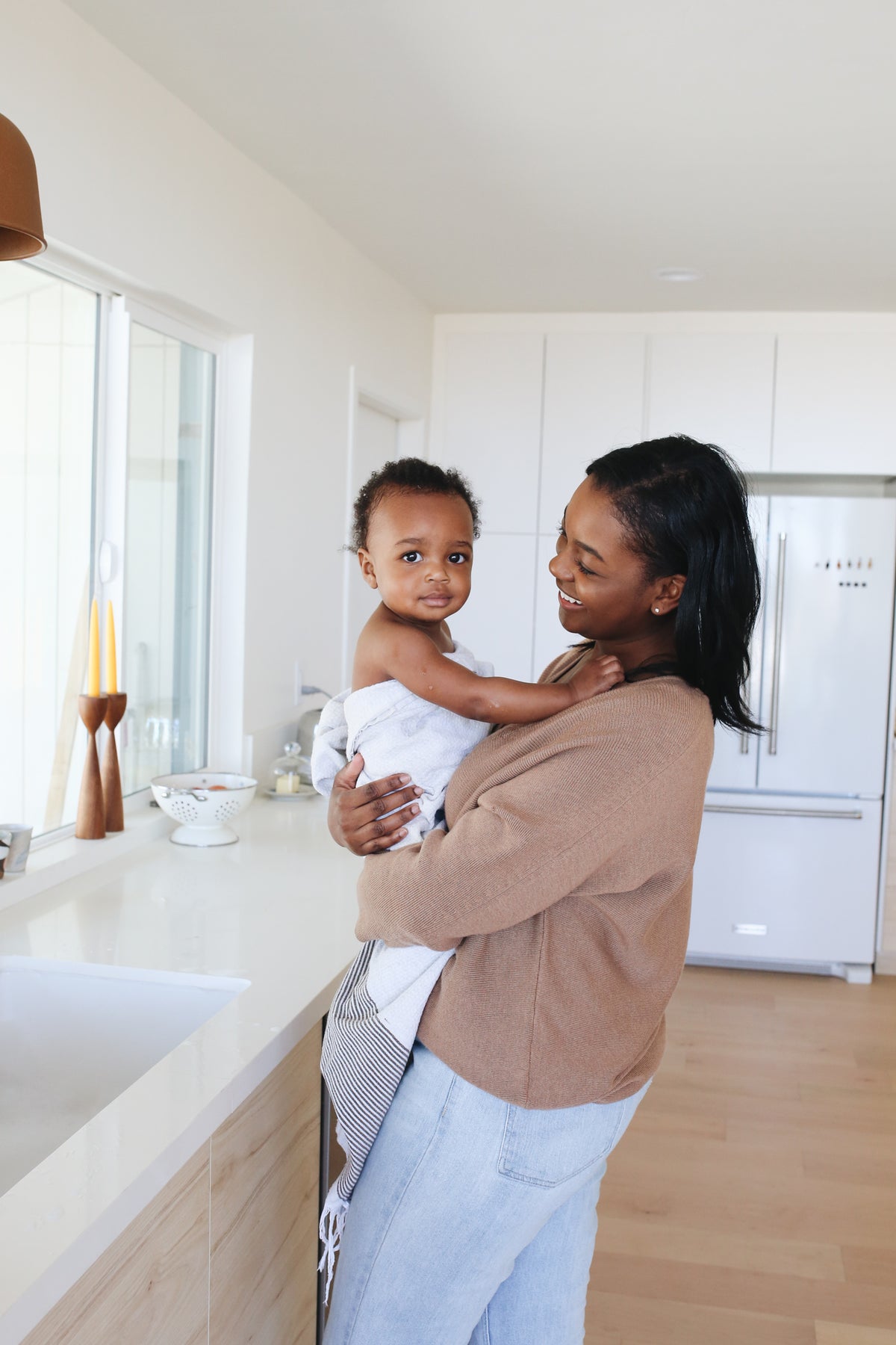 Woman holding a child in a modern kitchen