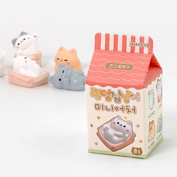 Cartoon cat figurines with a milk carton-shaped box on a white background