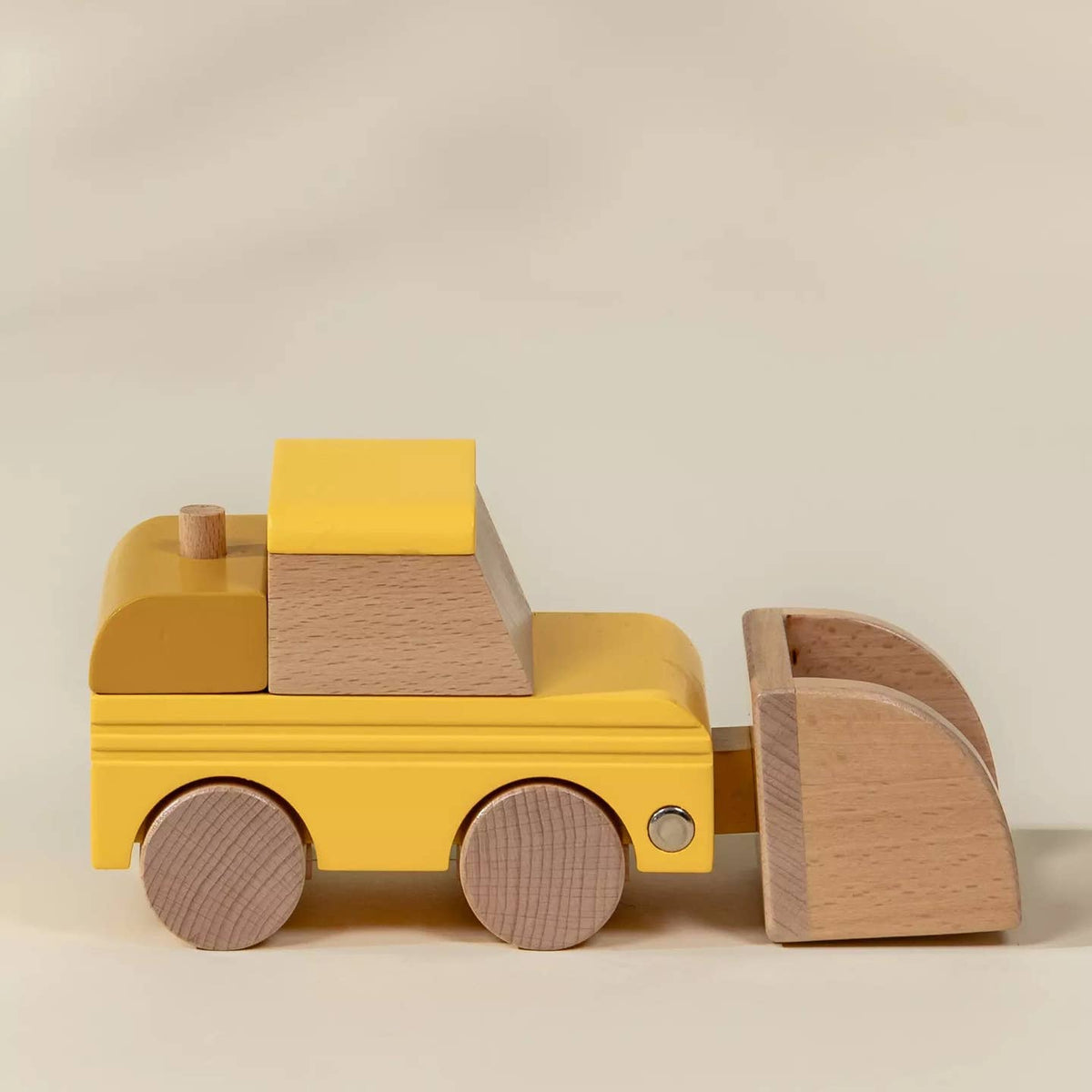 Wooden toy truck with yellow body and brown accents on a beige background