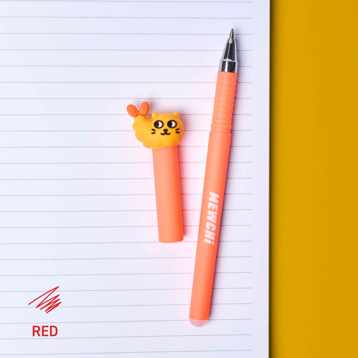 Two orange pens with cat-shaped tips on lined paper with a yellow background