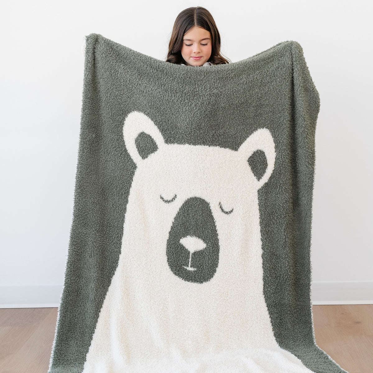 Person holding a blanket with a bear design