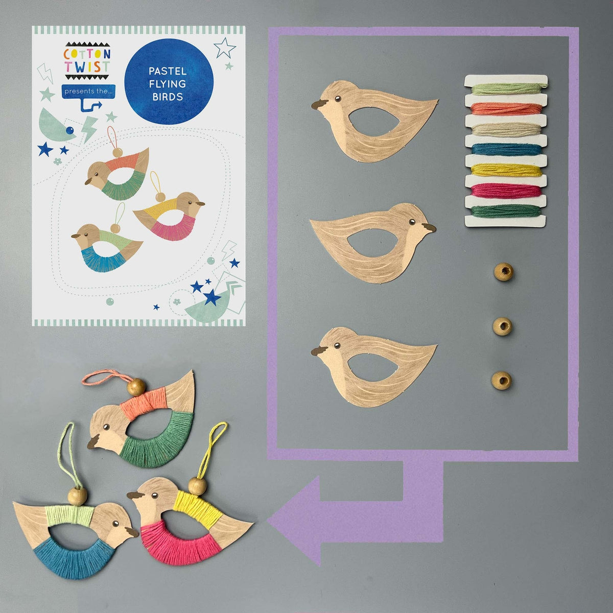 Wooden bird ornaments with colorful strings and a craft sheet on a gray background