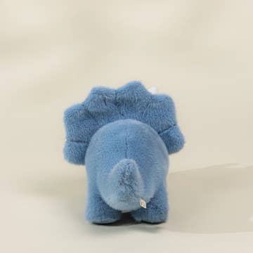 A small blue plush dinosaur toy shown from the back, photographed against a plain light beige background.
