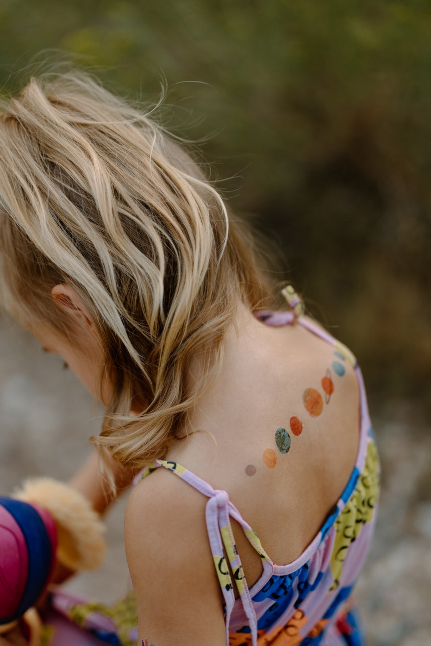 Child with colorful temporary tattoos outdoors