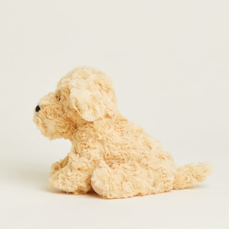 A side-profile view of the Golden Dog Junior plush toy by Warmies, showing its cream-colored textured fur and sitting posture.