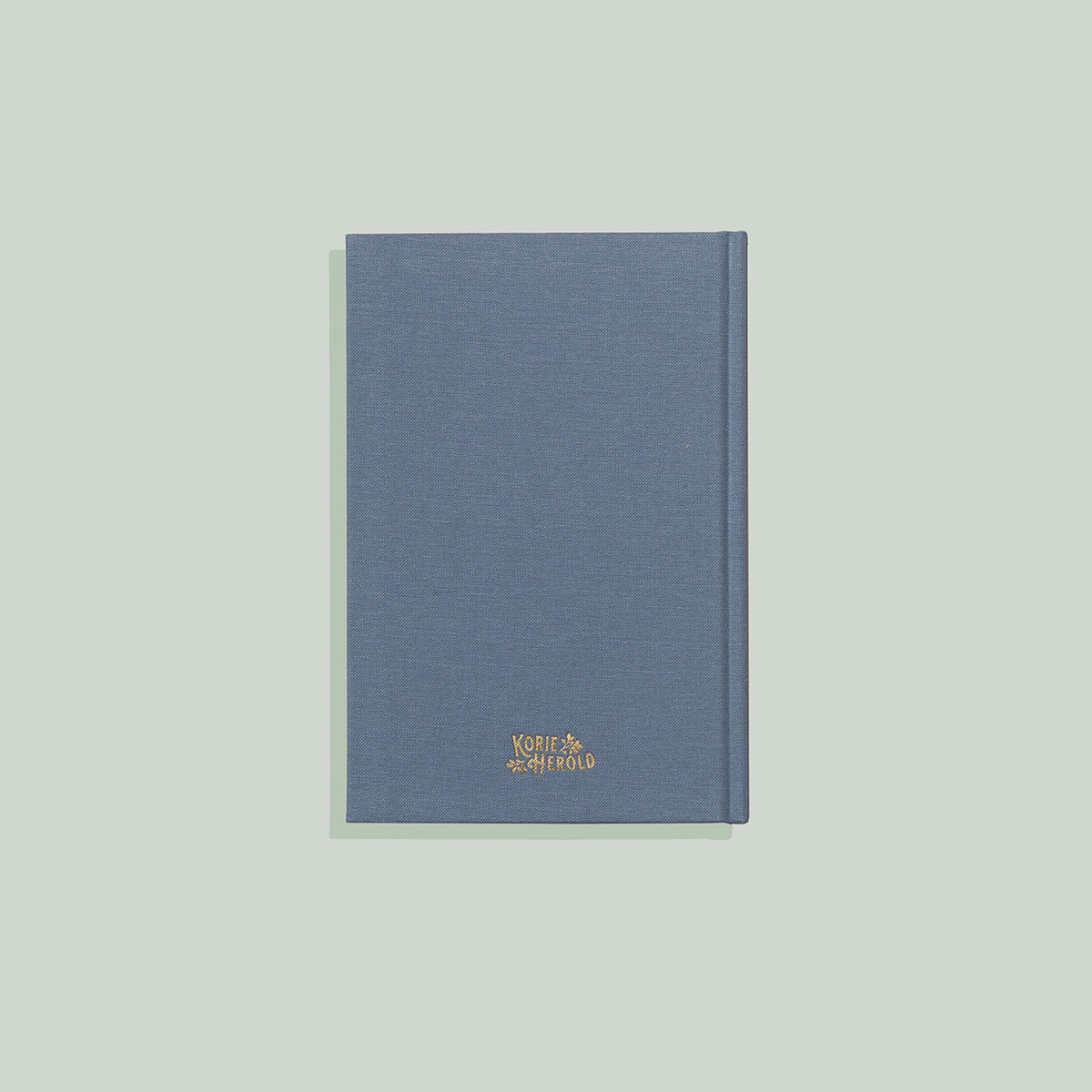 Blue notebook with a gold logo on a light gray background