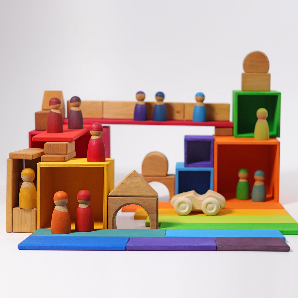 Colorful wooden toy set with blocks and figures on a white background