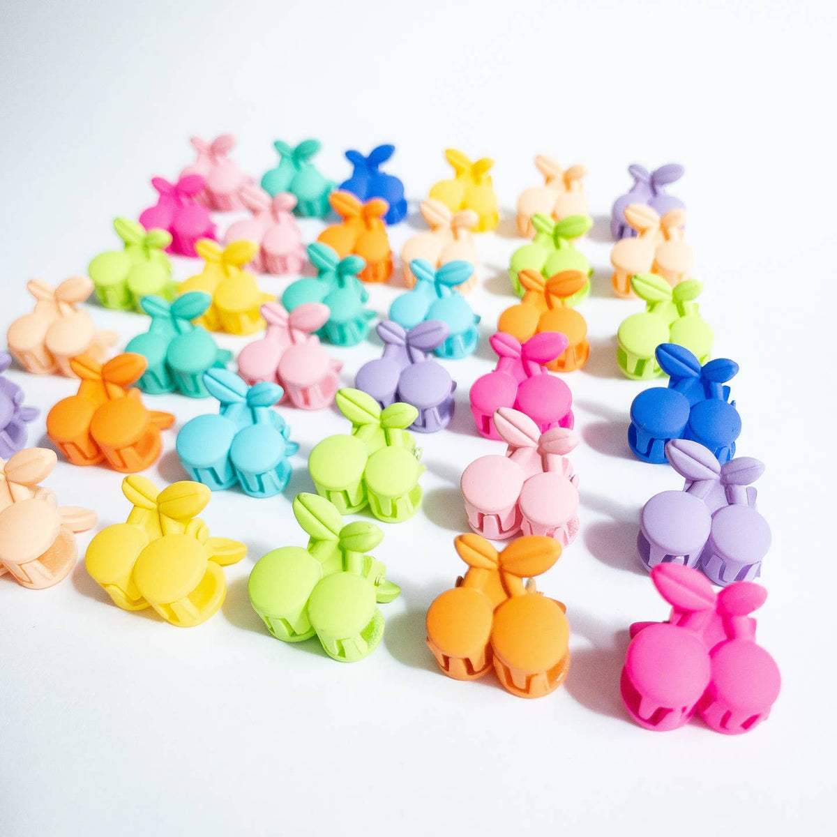 Colorful bunny-shaped clips arranged in a grid on a white background
