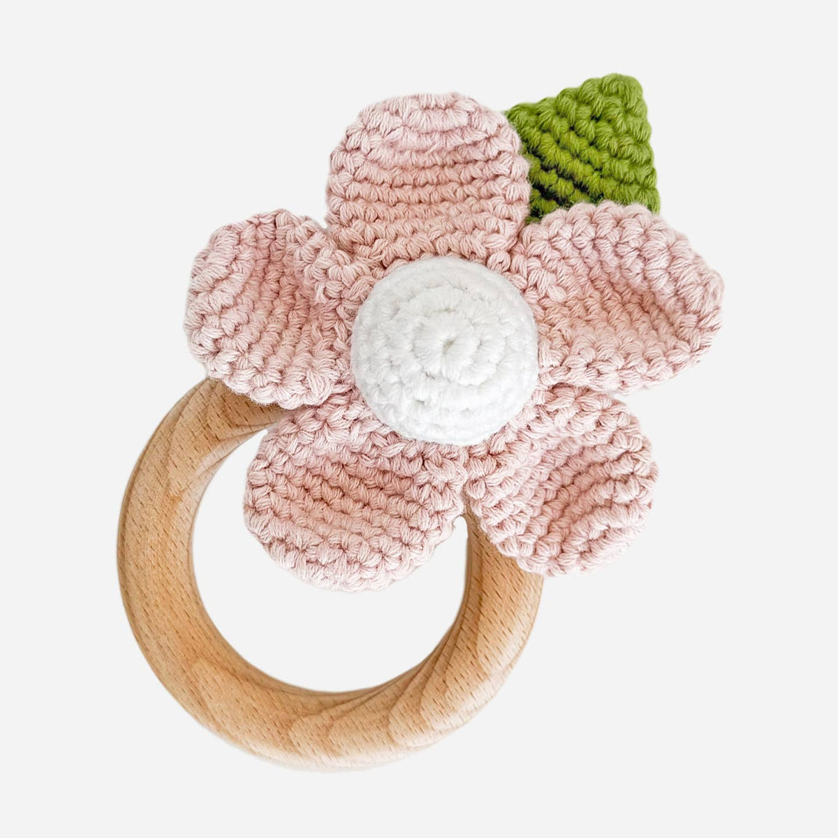 Crocheted flower teething ring with wooden base on a white background