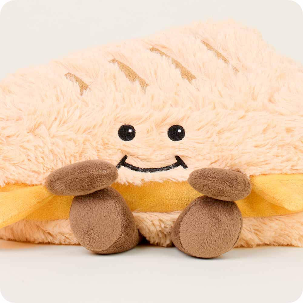 Plush toy resembling a sandwich with a smiling face on a white background