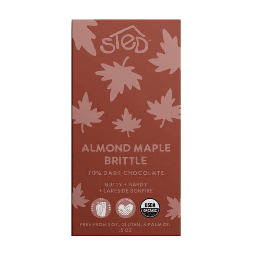 A single boxed chocolate brittle bar on a plain white background. The package is reddish brown with pale pink leaf illustrations and white text reading 'sted' and 'Almond Maple Brittle 70% Dark Chocolate.