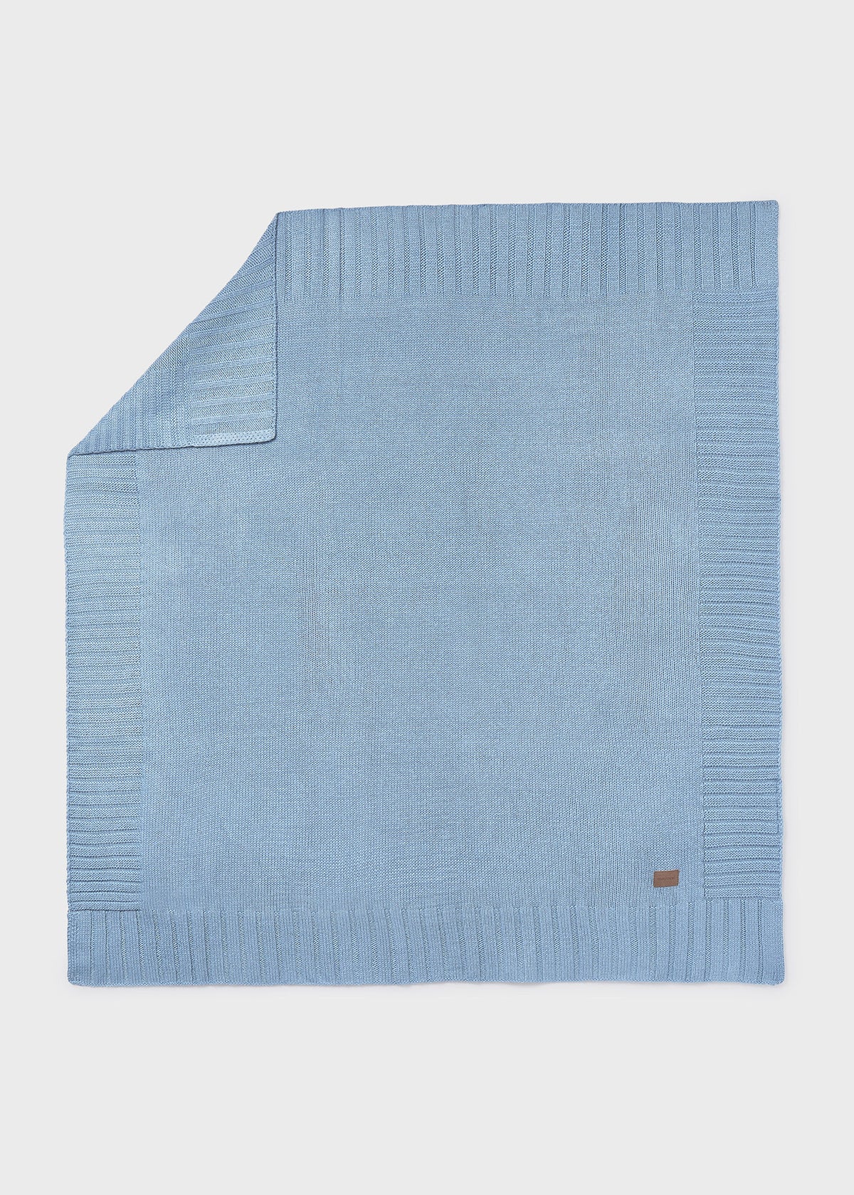 Light blue knitted blanket on a white background