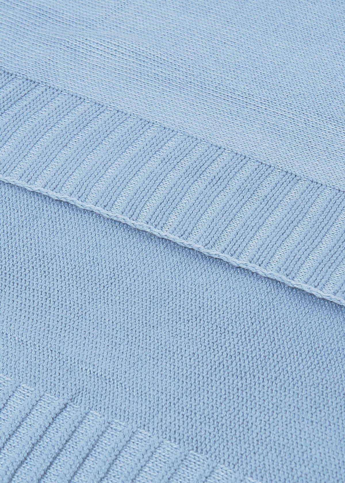Close-up of a light blue knitted fabric with ribbed texture.