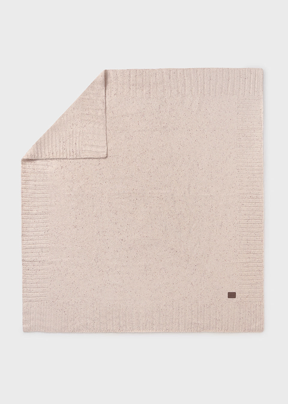 Beige textured blanket with a small logo on a light gray background