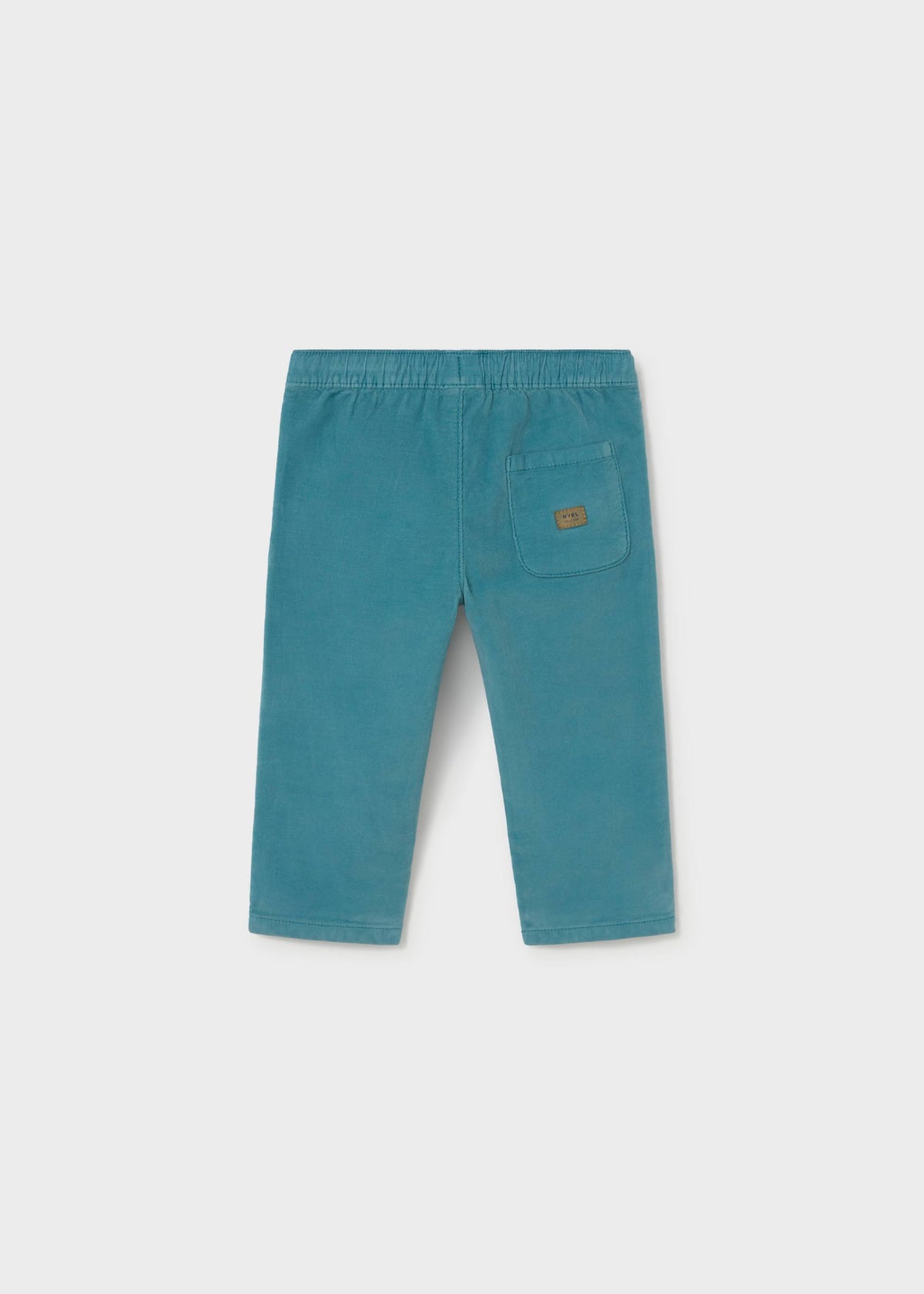 A pair of teal corduroy pants for toddlers, shown from the back on a light gray background. The back features an elastic waistband, straight legs, and a single patch pocket on the right side with a small brown brand label.