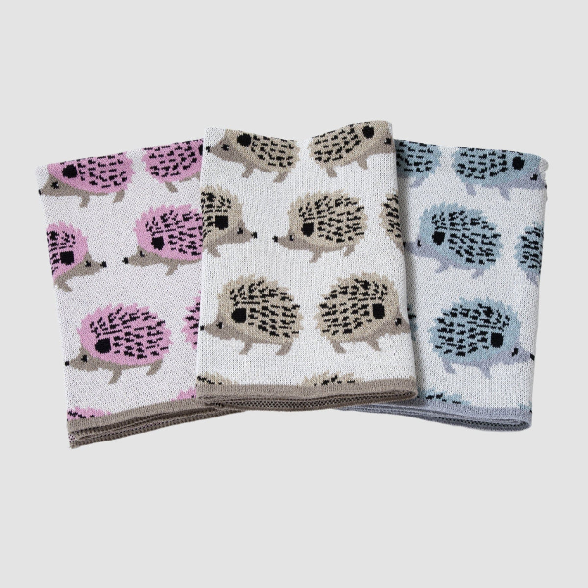 Three folded towels with hedgehog pattern on a white background