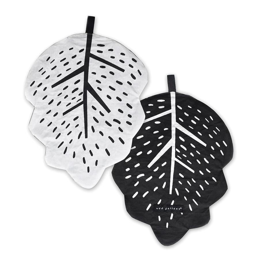 Two leaf-shaped coasters, one white and one black, with black text on a white background.