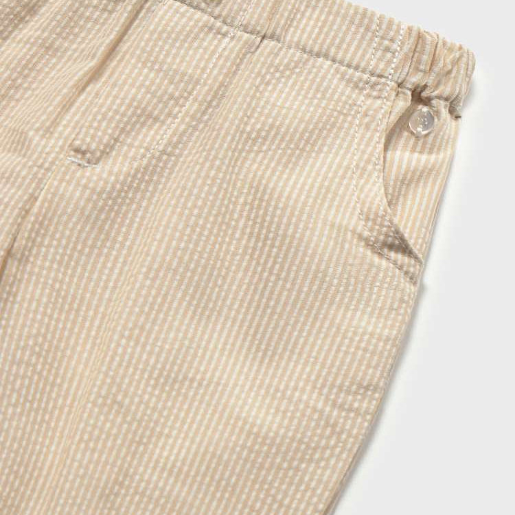 Close-up of beige corduroy pants with a white background