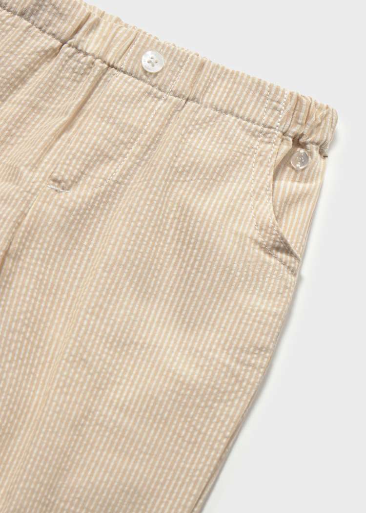 Close-up of beige corduroy pants with a white background