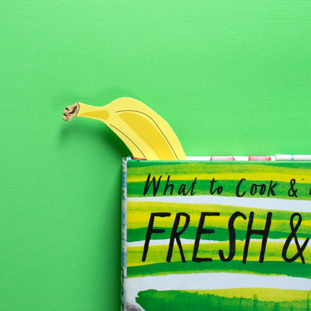 Banana sticking out of a box labeled 'What to Cook & Fresh &' on a green background