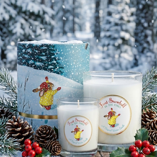 Candle with a winter scene label in a snowy forest setting
