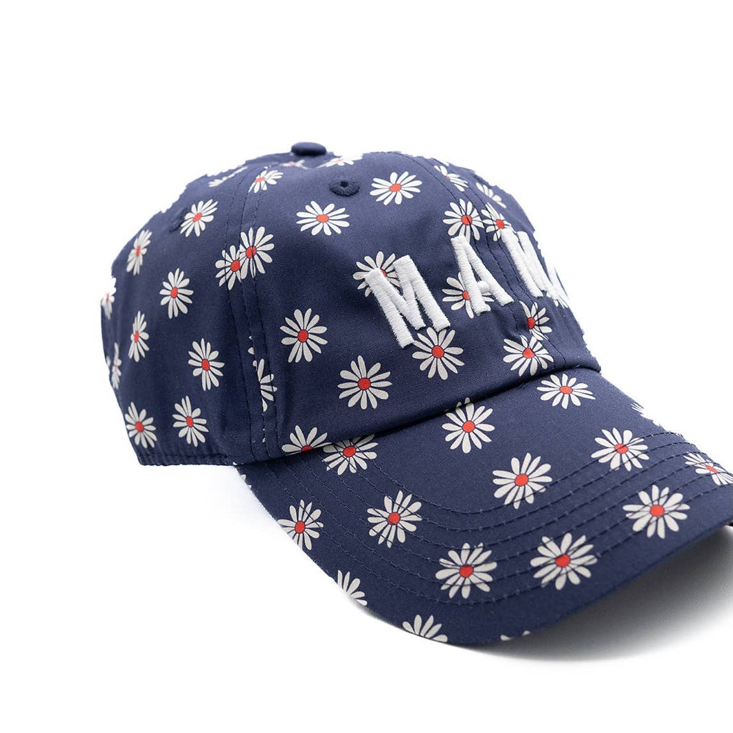 Navy blue cap with white floral pattern and red centers on a white background