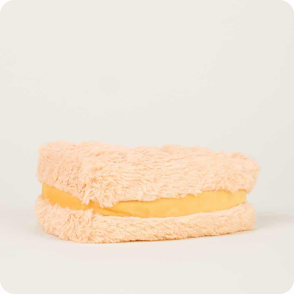 Plush toy resembling a sandwich with beige bread and yellow filling on a light gray background