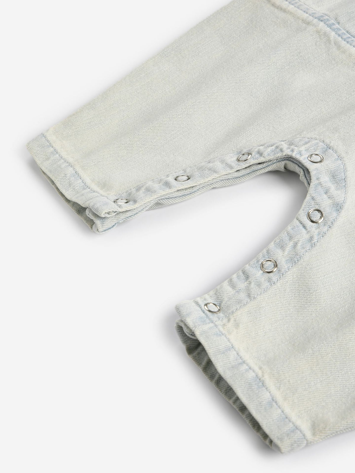 Close-up of light gray denim shorts with frayed edges on a white background