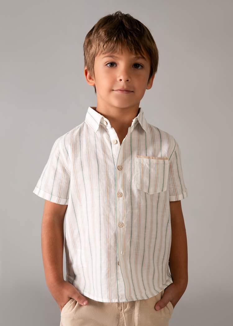 Young boy wearing a striped shirt against a plain background