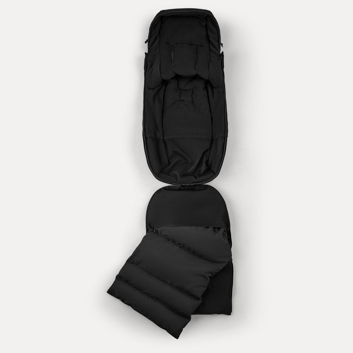 Black backpack with a folded black sleeping pad on a white background