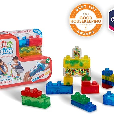 Product photo of the Jelly Blox Creative Kit by Continuum Games showing its red packaging box alongside various colorful, translucent squishy building blocks, feature awards from Good Housekeeping and Toy Insider in the background.